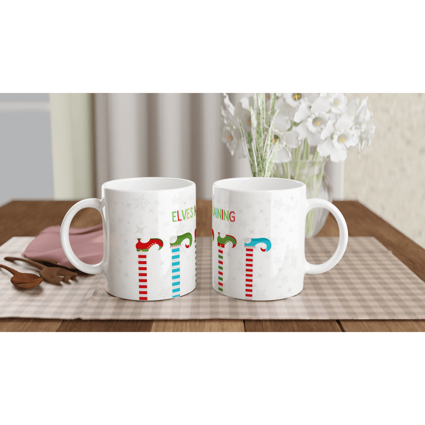 white mugs with colorful designs of elves on it with the text, 'elves in training'.
